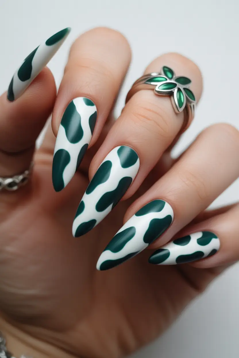minimalistic spring nail inspo 2026 Graphic Green Almond Nails with a Playful Cow Print Twist