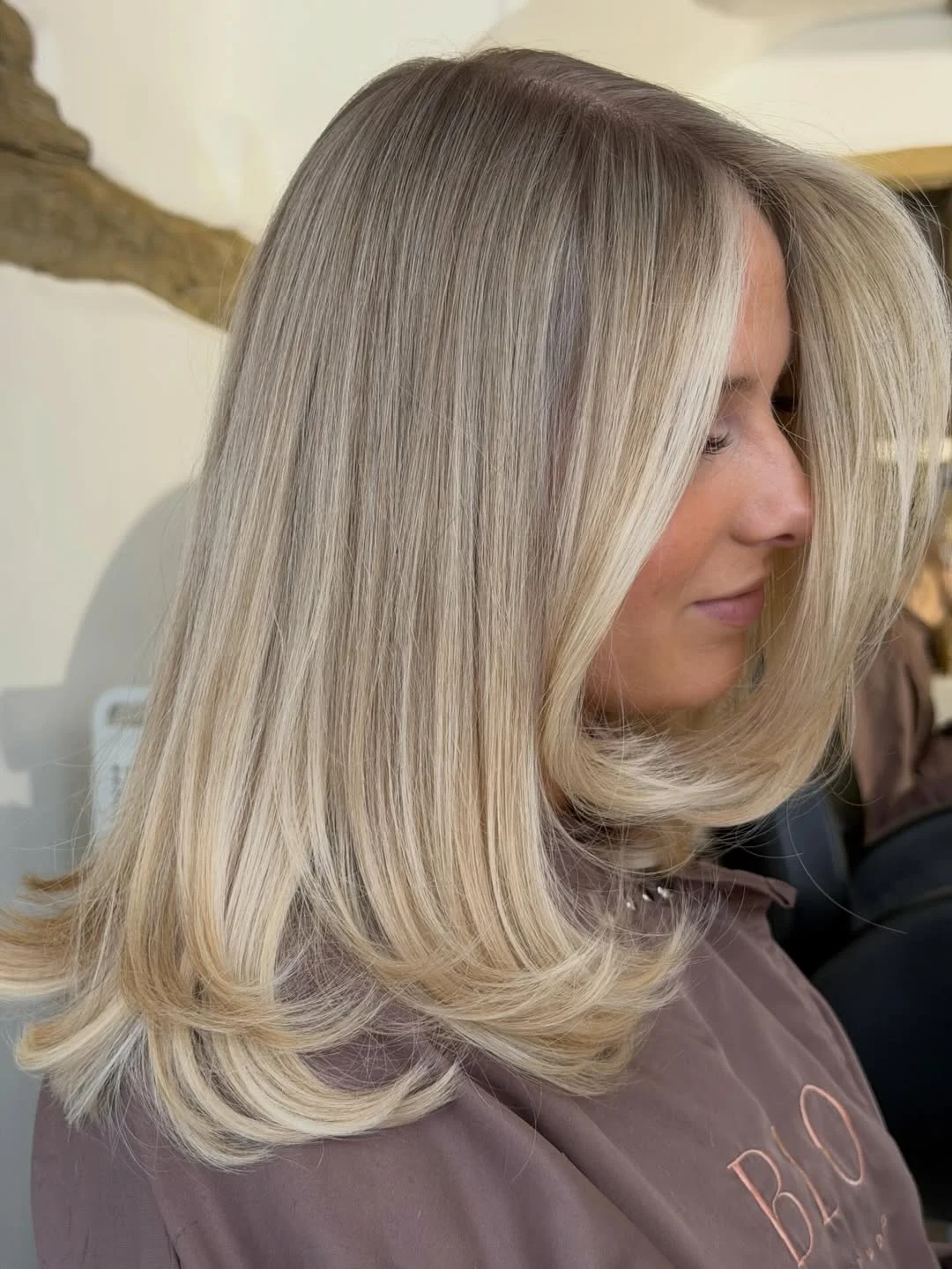 flattering summer haircut for round face 2026 Rounded Blonde Blowout with Soft Ends