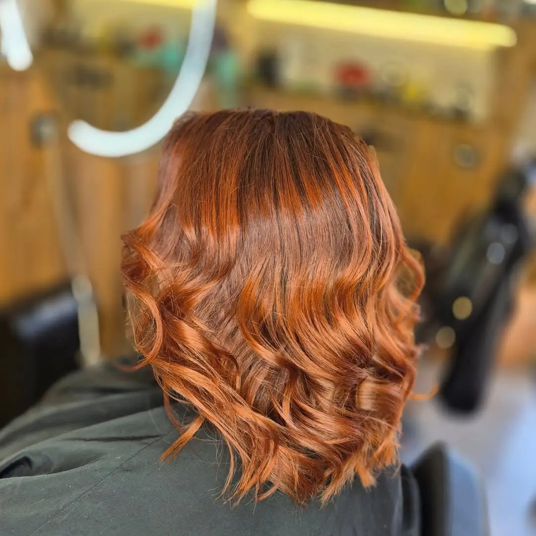 summer hair color for dark skin women 2026 Copper ginger waves with a luminous glow