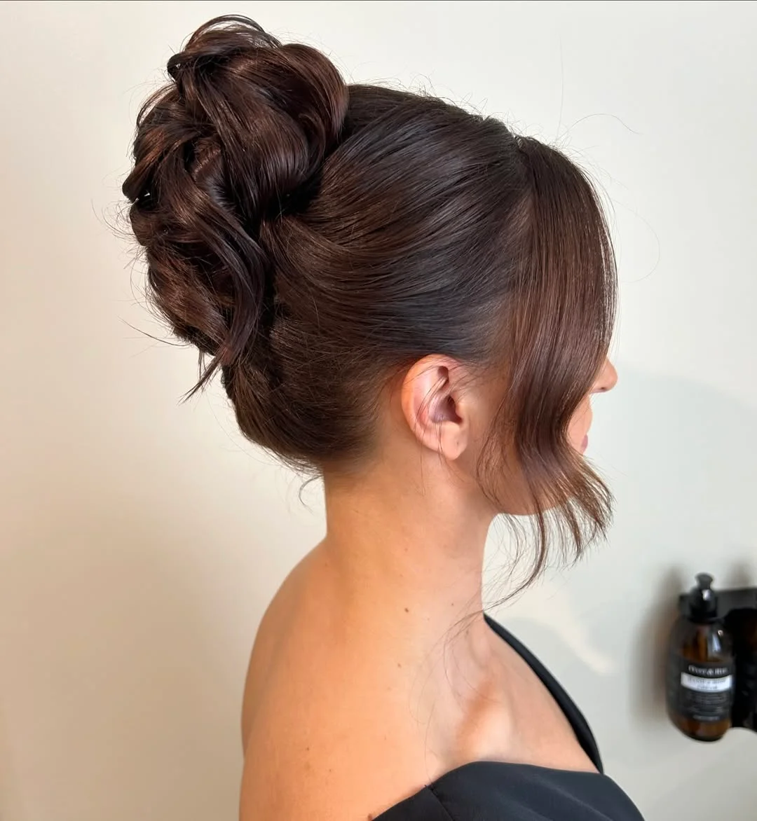 elegant summer updo hairstyles 2026 Glossy Brunette Voluminous Knot with Side Tendrils