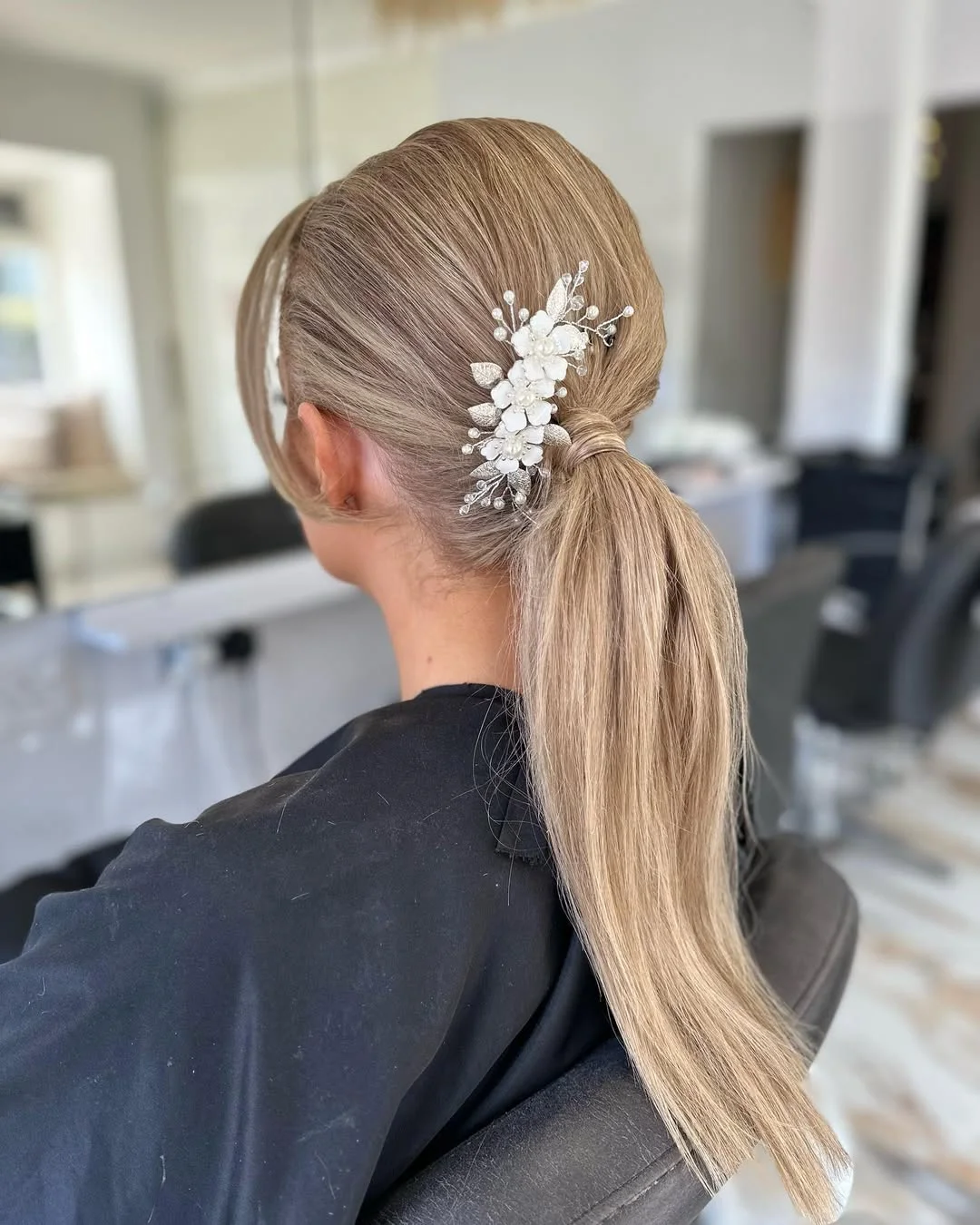 elegant summer wedding guest hairstyles 2026 Sleek Floral Ponytail