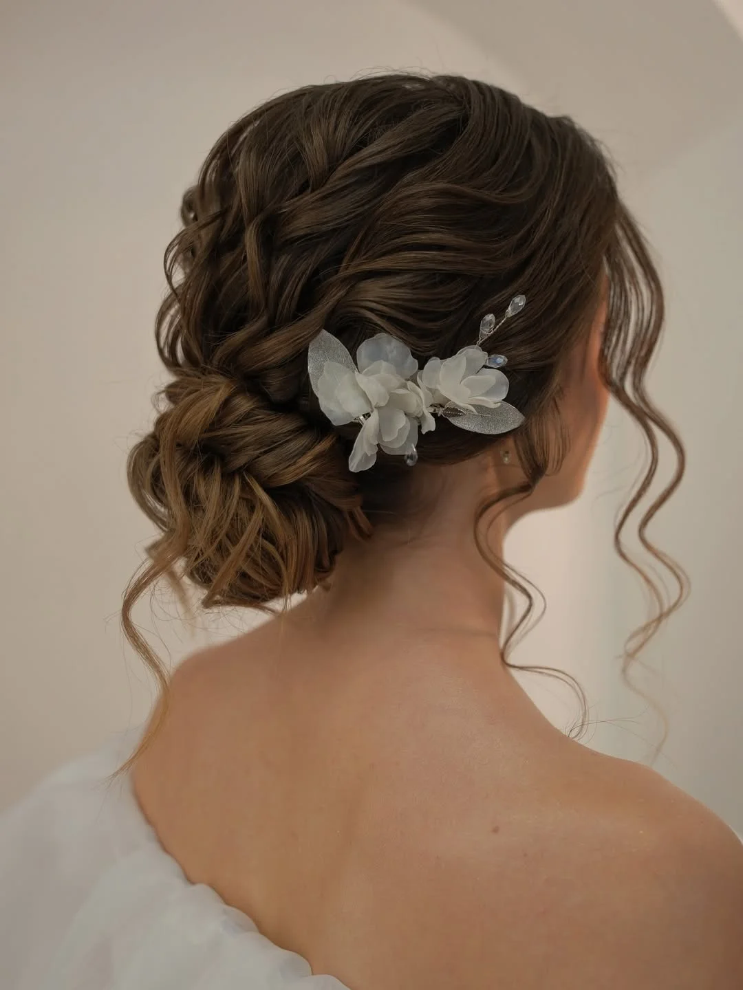 messy summer bun hairstyles 2026 Curly Textured Bun With Floral Detail