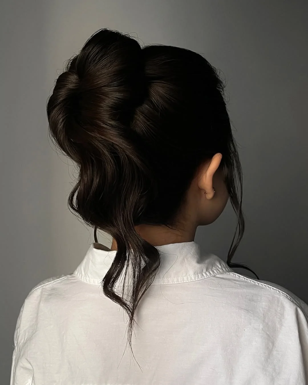 messy summer bun hairstyles 2026 Slick High Bun With Dramatic Shape