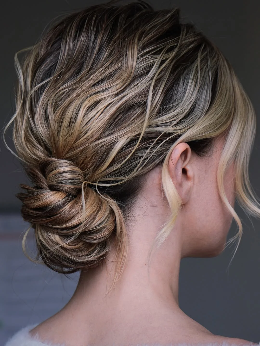 messy summer bun hairstyles 2026 Glossy Low Bun With Blonde Dimension
