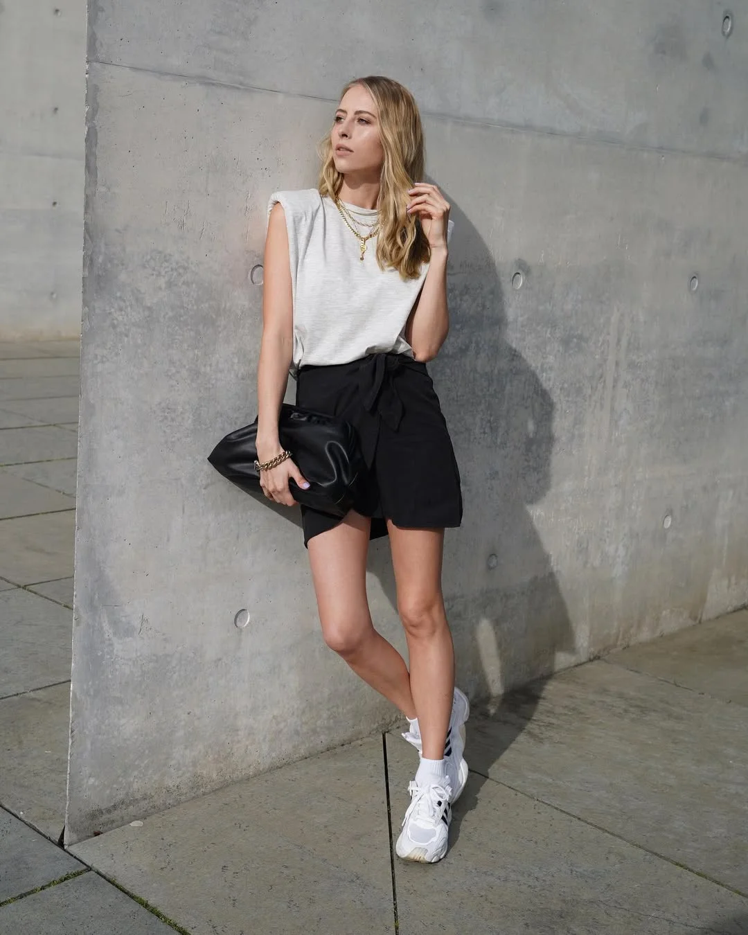 fall skirt and sneakers outfits 2026 Minimalist Black Wrap Skirt with Modern Sneakers