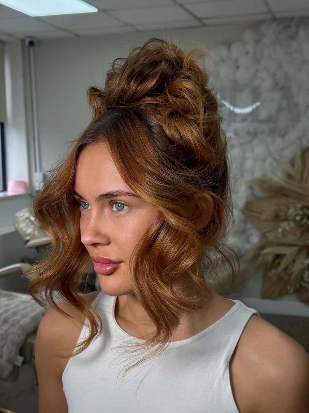 fall hairstyles for wedding guests 2026 Relaxed Textured High Bun With Soft Waves