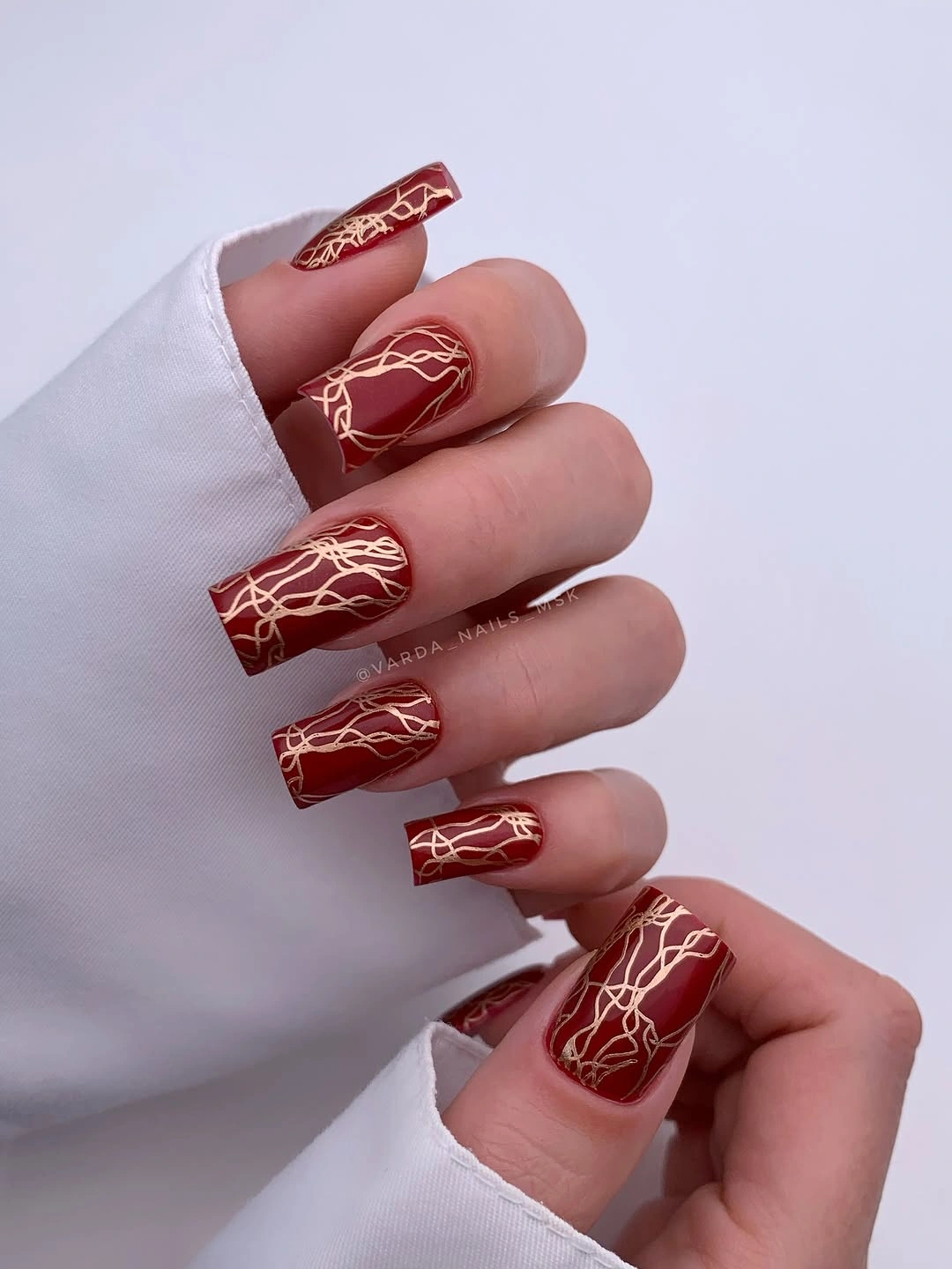 fall manicure 2026 Deep Burgundy Nails With Abstract Gold Lines