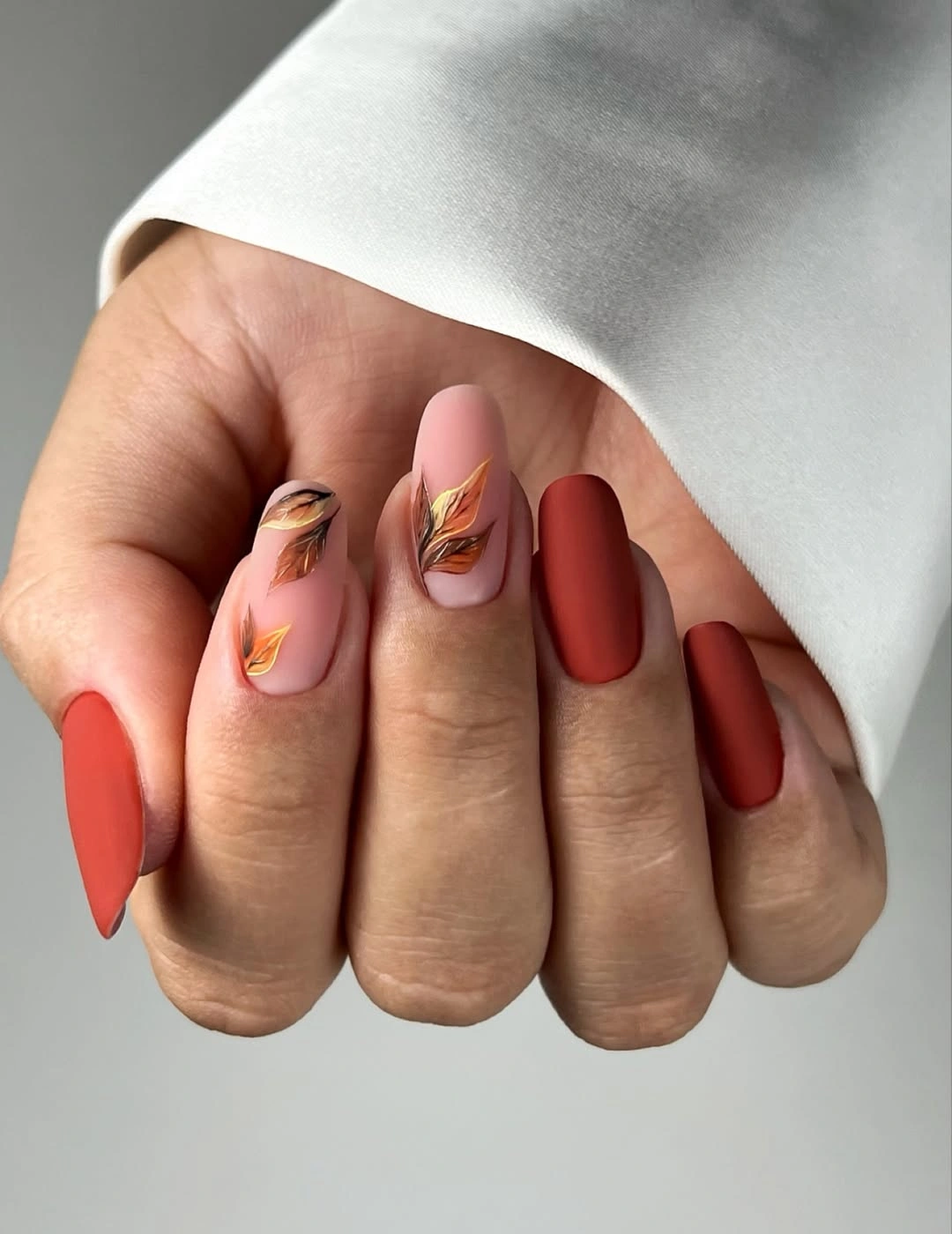 fall medium nail ideas 2026 Matte Terracotta Nails with Delicate Autumn Leaves