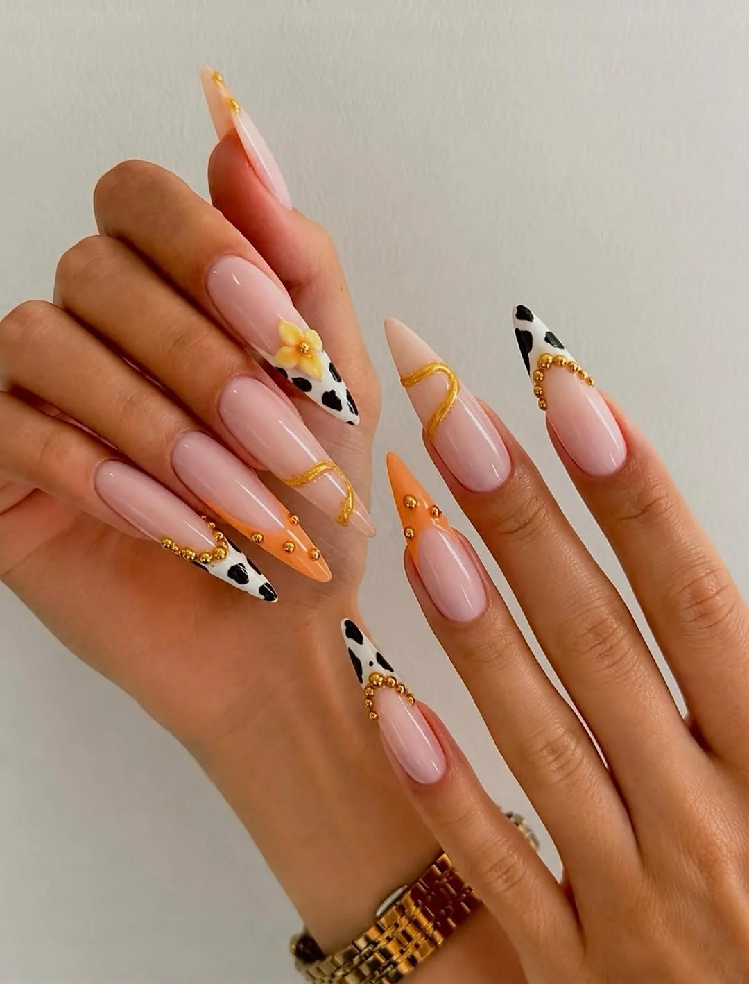trendy nail colors for august 2026 Peach And Cow Print Accent Almond Nails