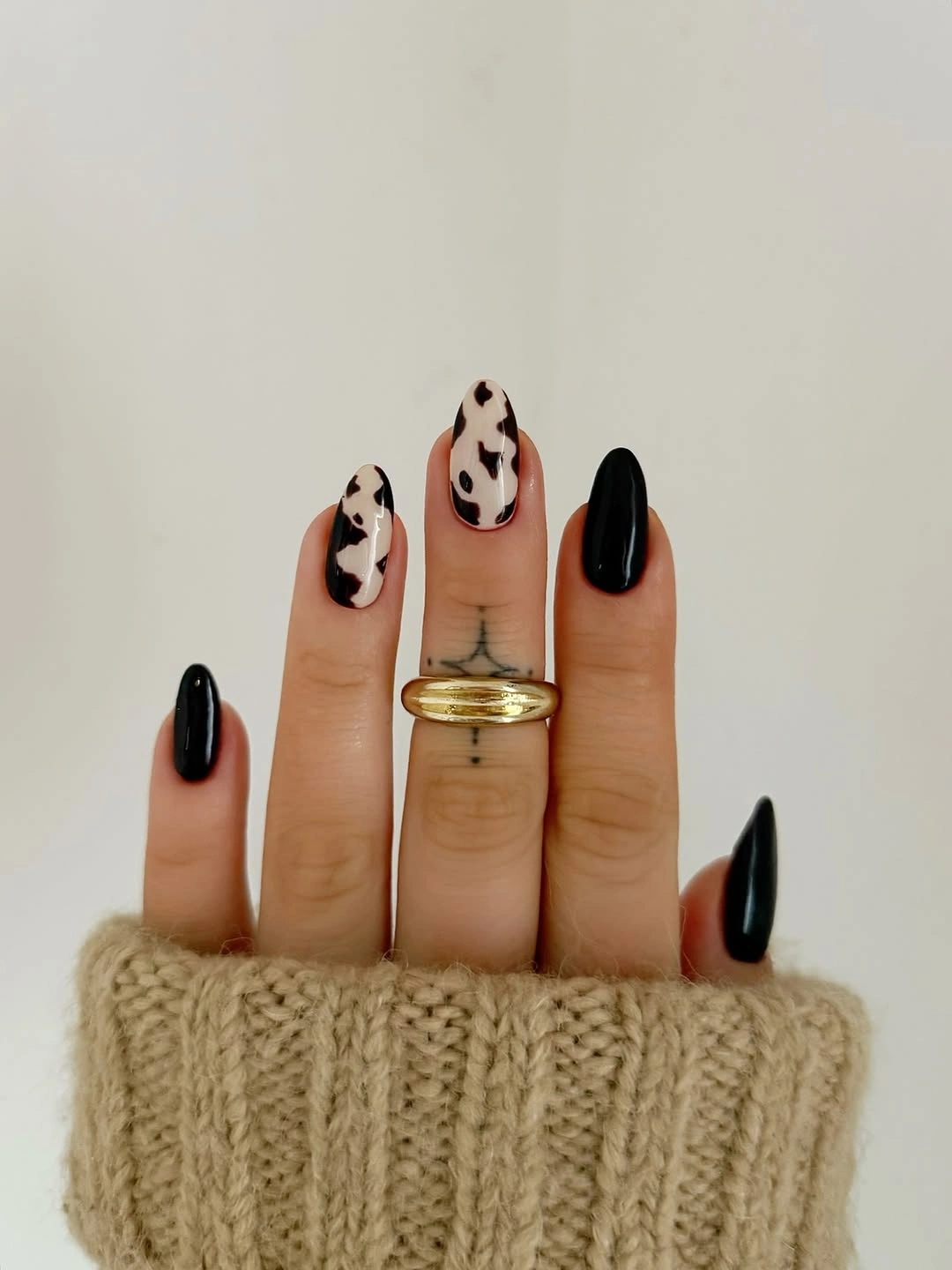 fall acrylic nails 2026 Modern Black And Cream Cow Print Nails