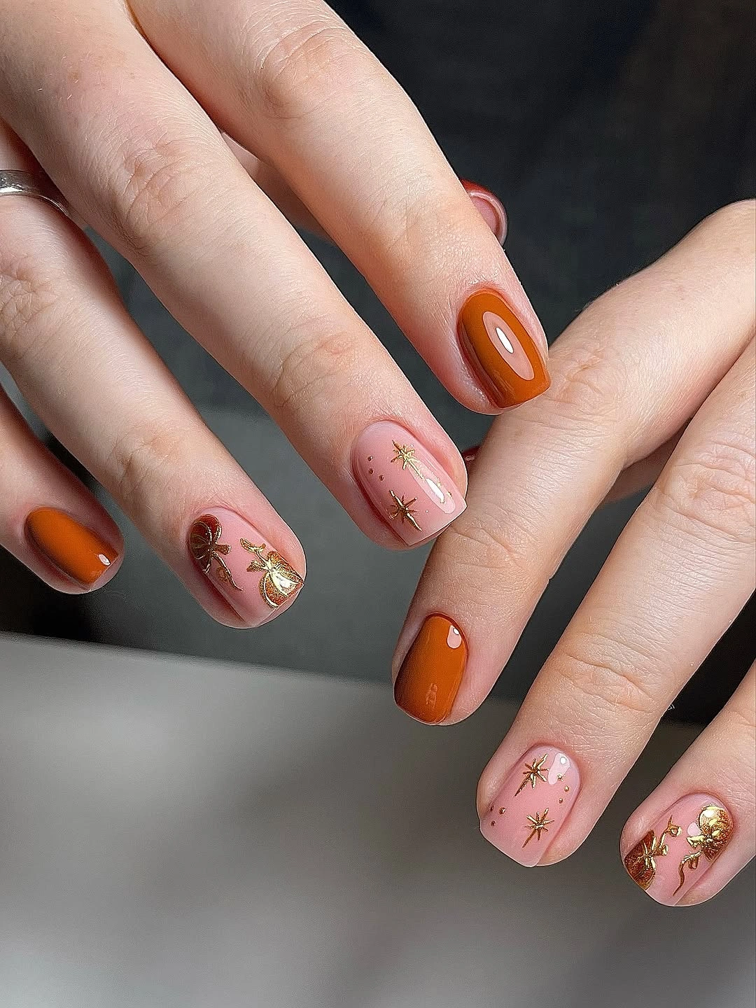 fall nail art ideas 2026 Burnt Orange Nails With Tiny Golden Charms