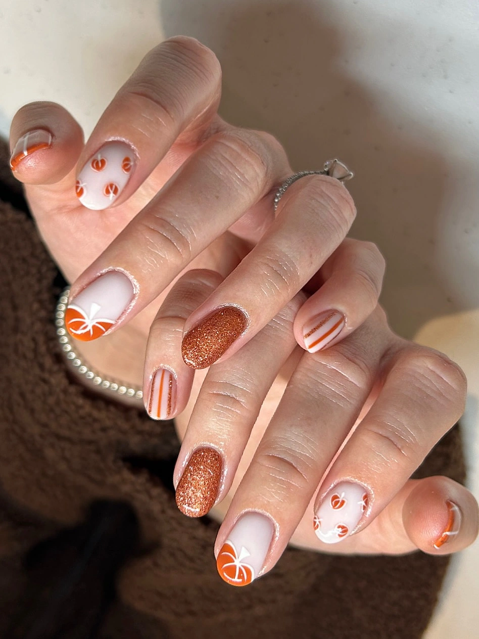 fall nail trends 2026 Pumpkin Spice Nails With Glitter Accents