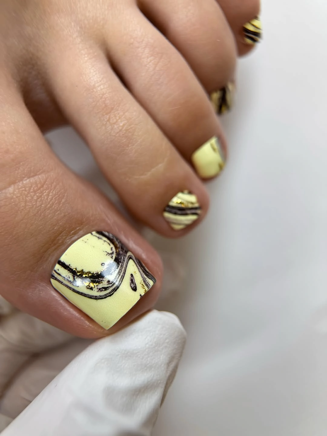 fall toe nails colors 2026 Butter Yellow Marble And Gold Pedicure