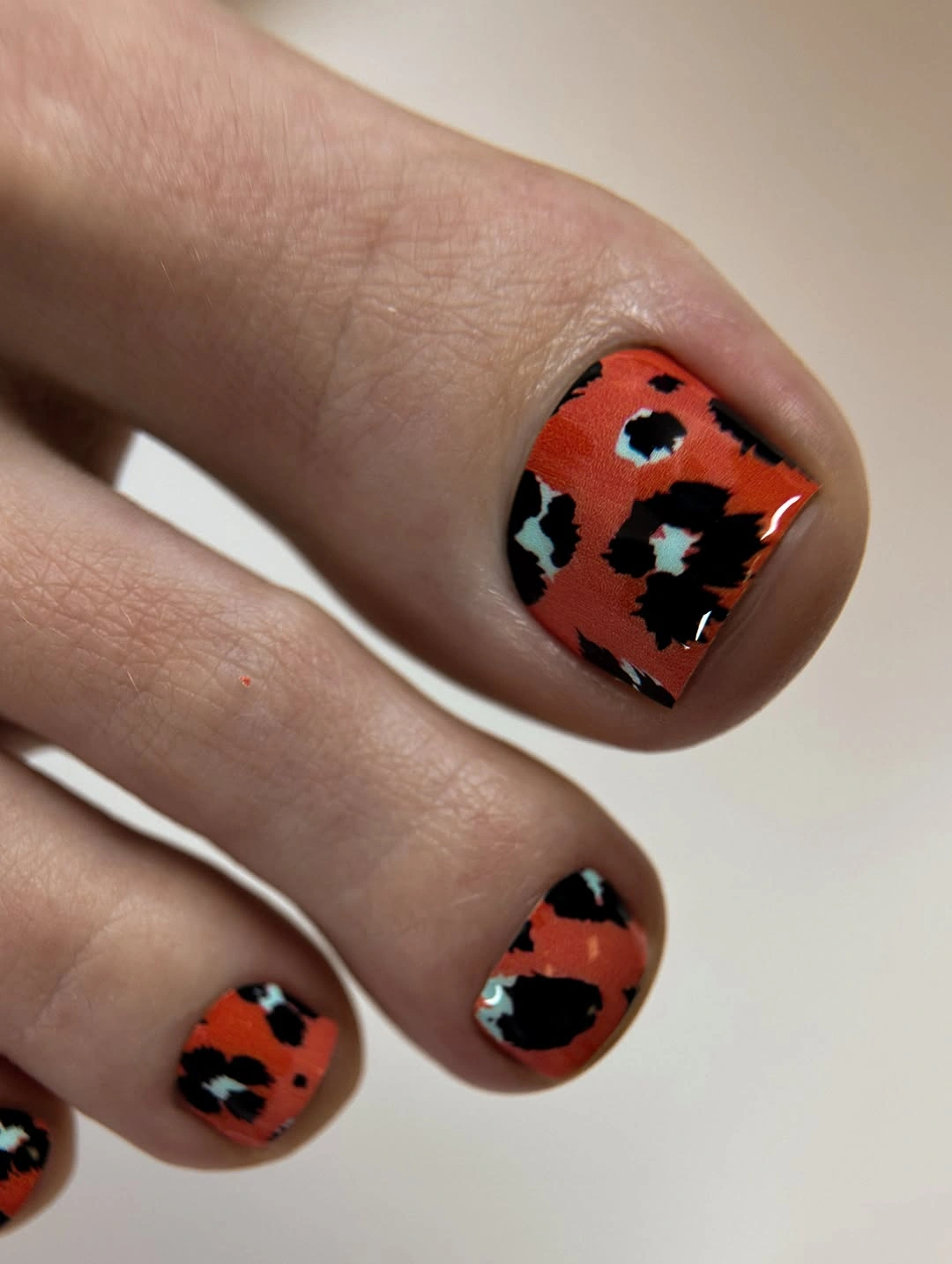 fall toe nails colors 2026 Burnt Orange And Black Animal Print Pedicure