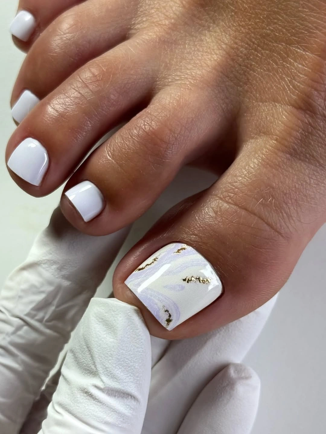 fall toe nails colors 2026 Soft White Marble With Gold Details