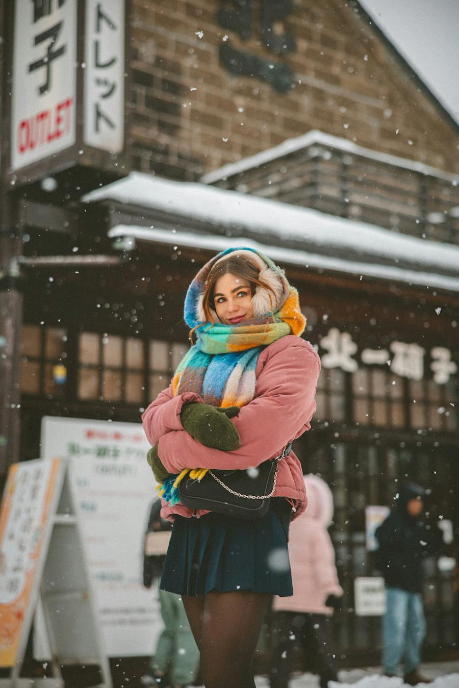 Pink Puffer Jacket with a Multicolor Knitted Scarf in Snowy Setting — Colorful Winter Outfits