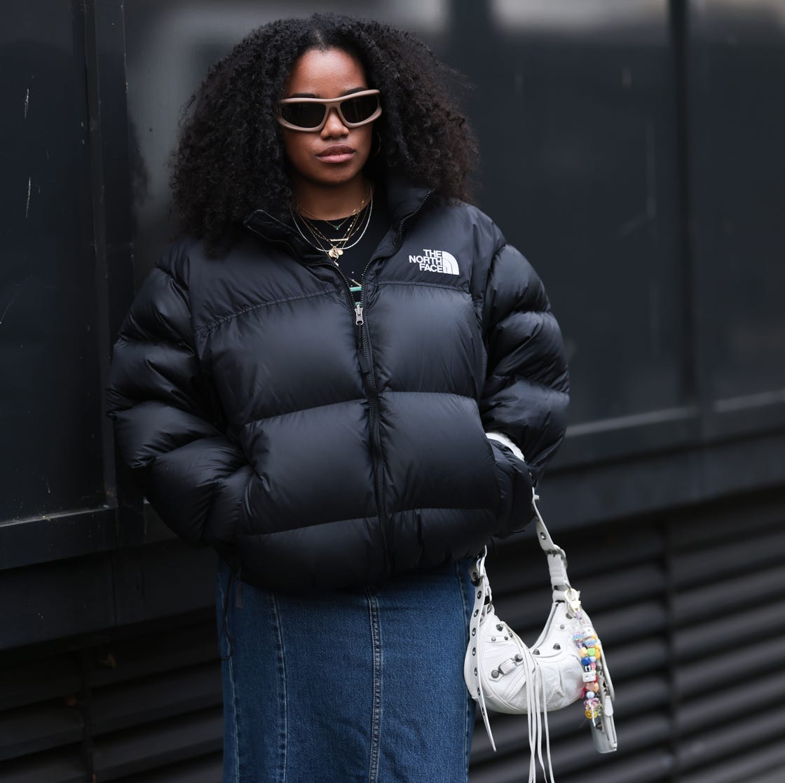 Logo Puffer Jacket Over T-shirt with Denim Skirt and Studded Bag — Winter Streetwear Outfits