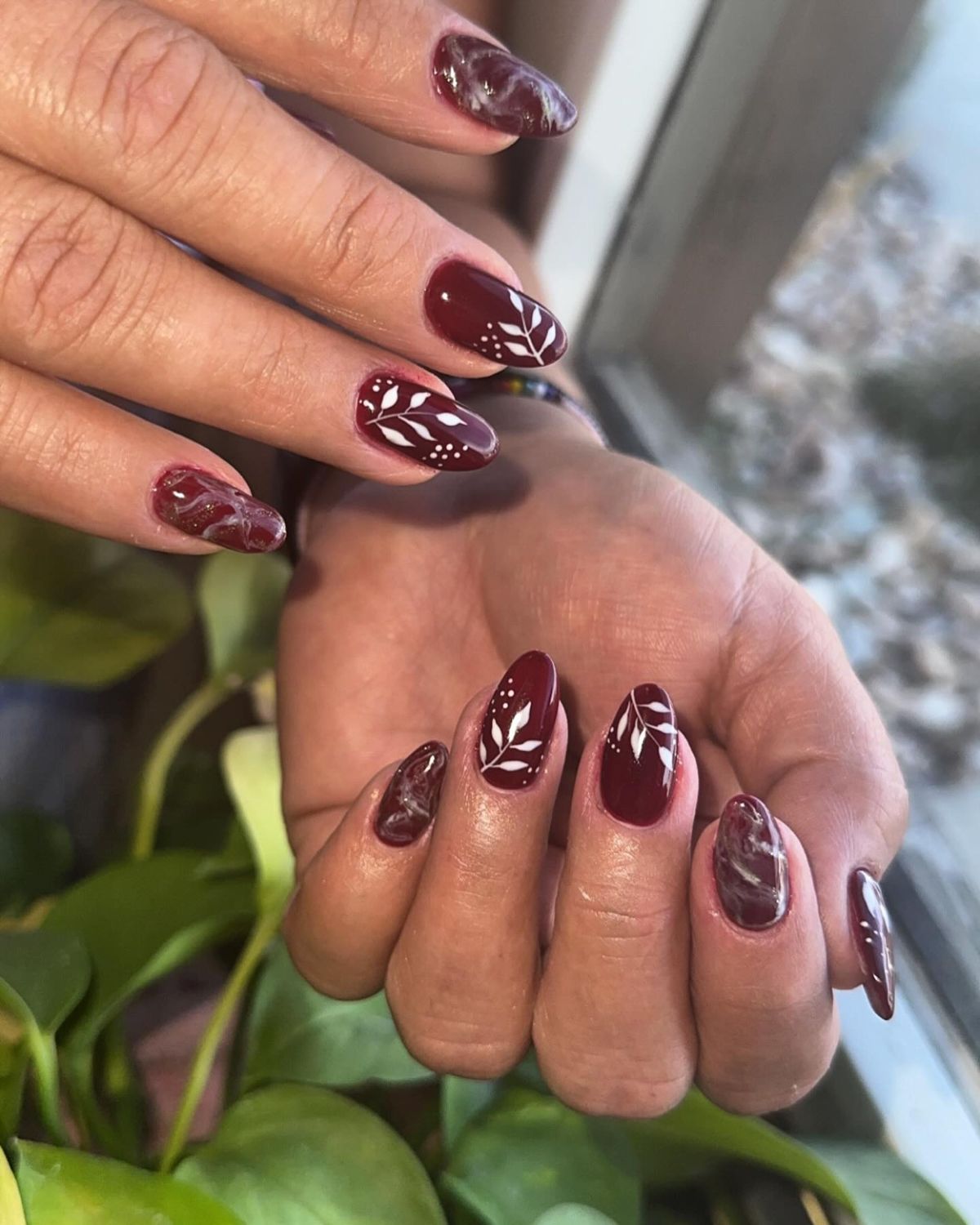 Artistic Burgundy Oval Nails with White Marble and Leaf Motifs — Burgundy Nails