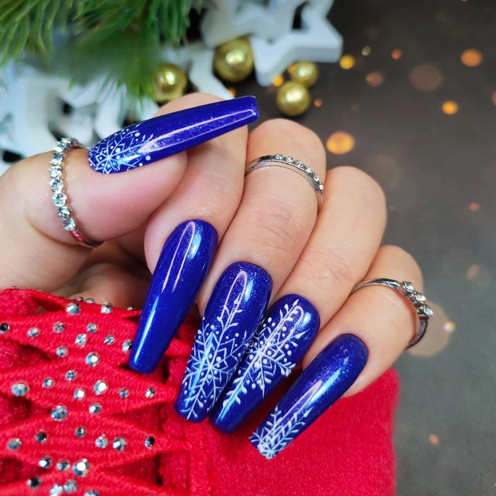 White Snowflakes On Accent Nails Visual Idea White Snowflakes On Accent Nails Visual Idea — Winter Blue Nails