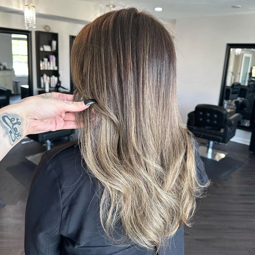Long layered ash brown hair with beige blonde lengths and softly wavy ends
