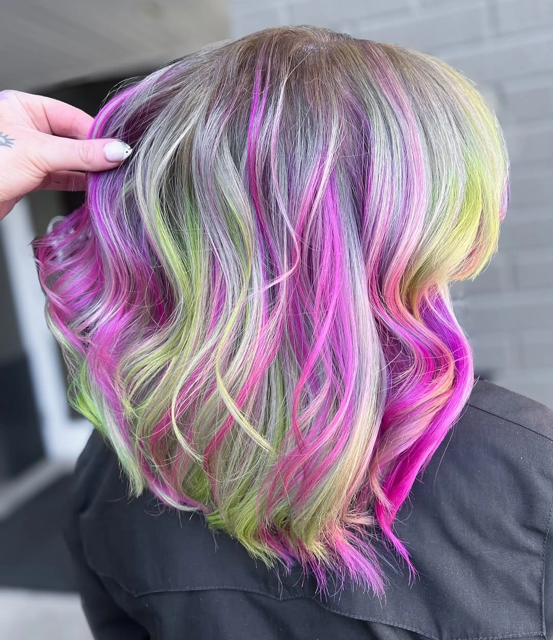 Medium length silver blonde waves with vivid pink purple and lime green strands