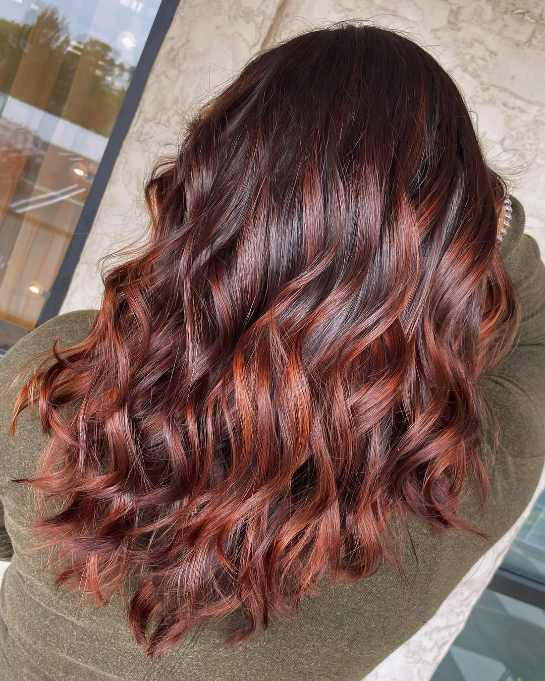 Long wavy auburn hair with deep reddish brown and bright copper strands