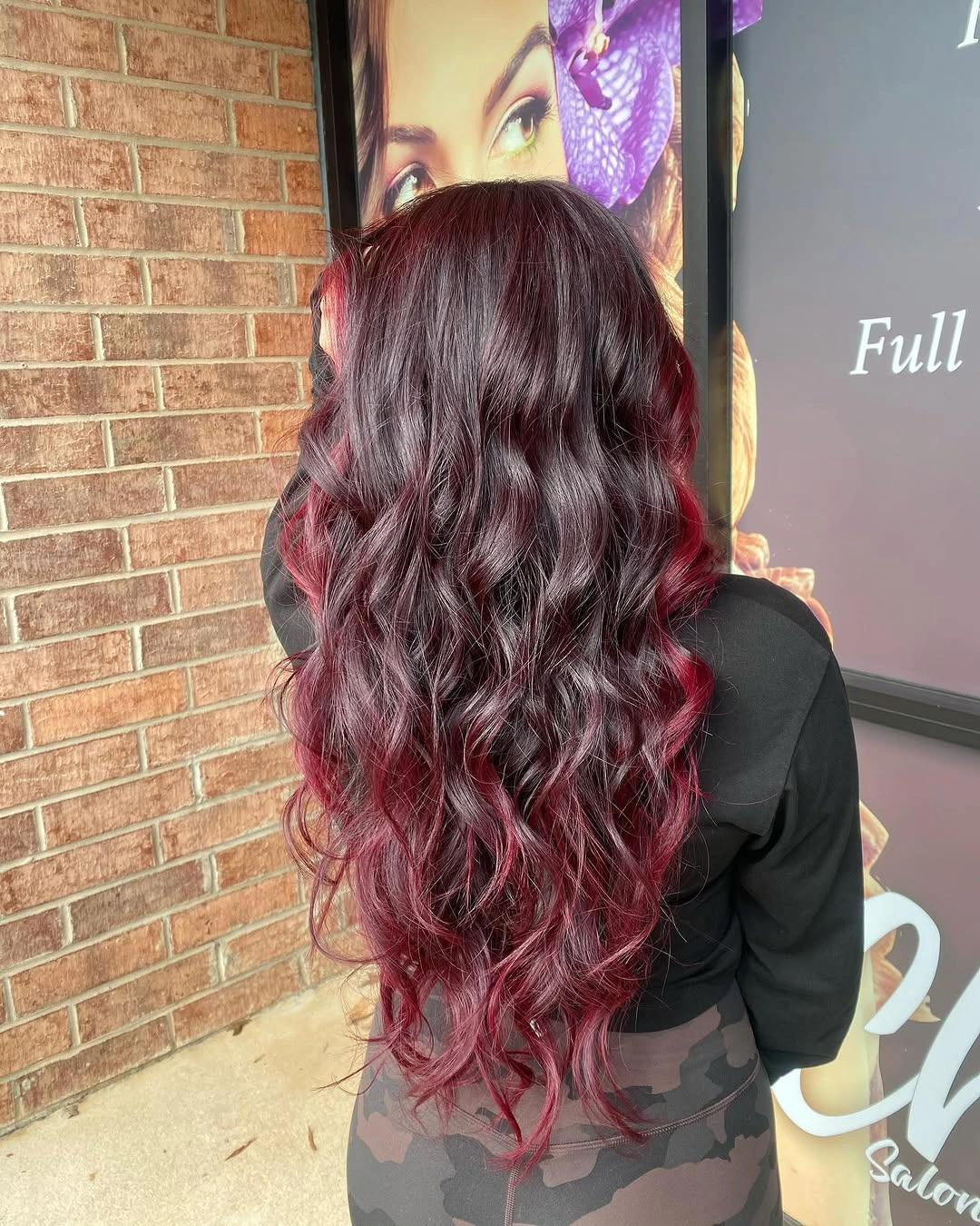 Long cascading burgundy waves with dark plum roots and wine red highlights