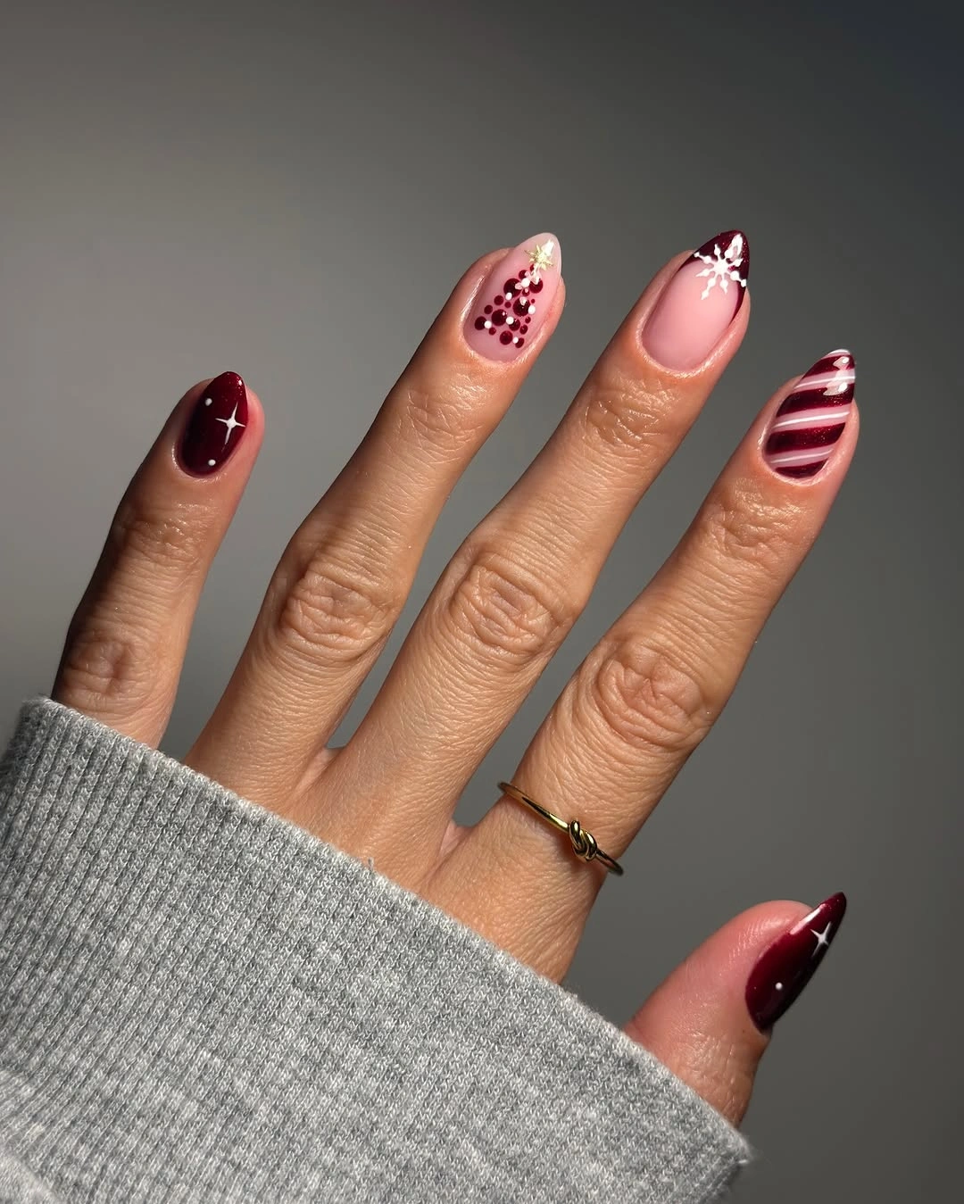 Burgundy and blush almond nails with white stars and striped accents