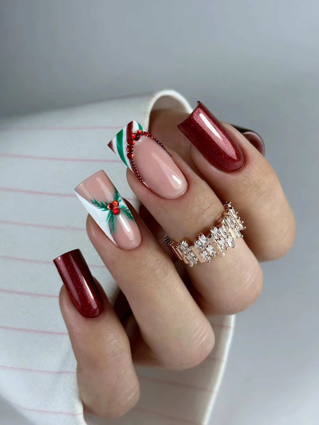 Square burgundy and nude nails with white tips and green leafy details