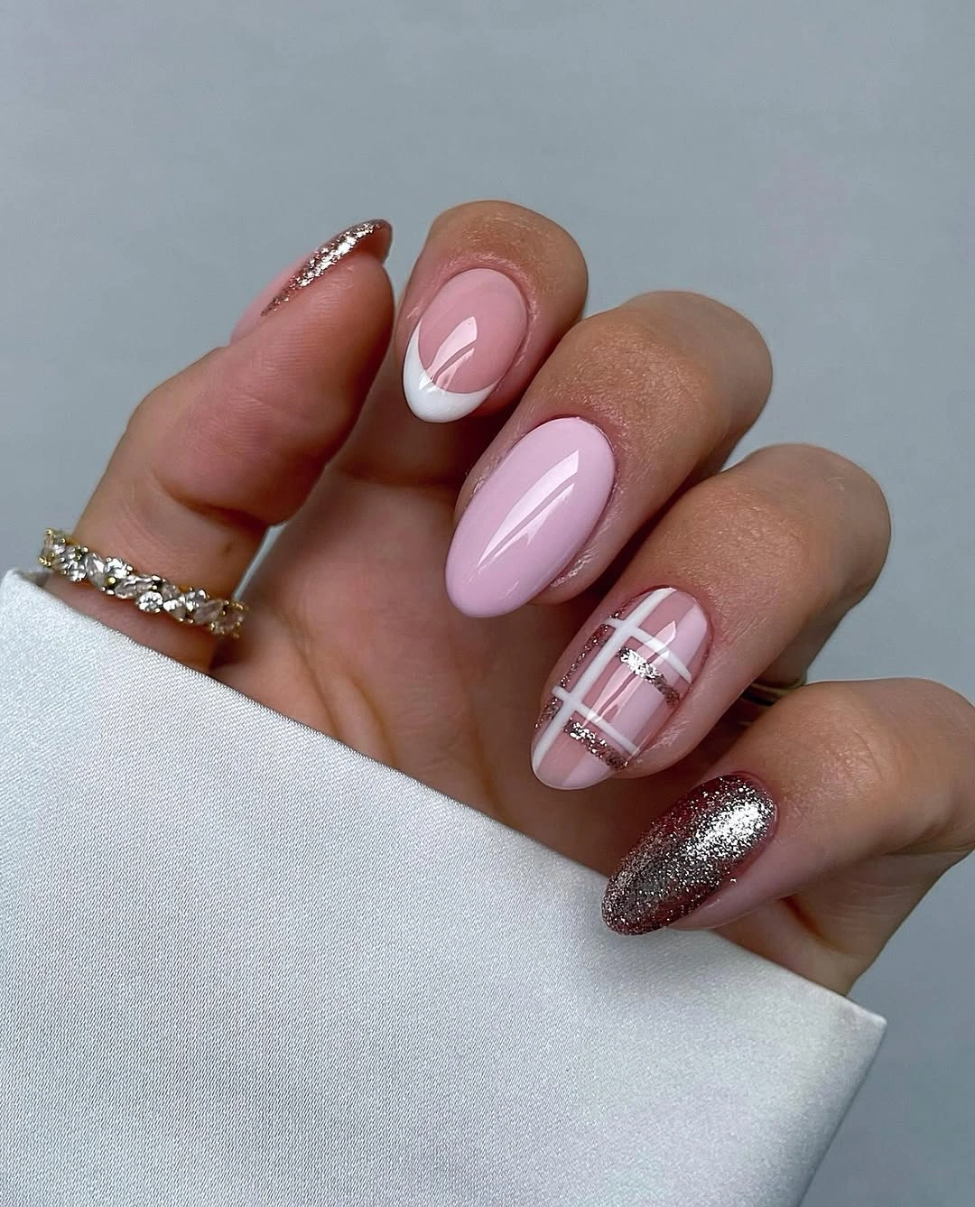 Pale pink almond nails with white tips plaid lines and glitter