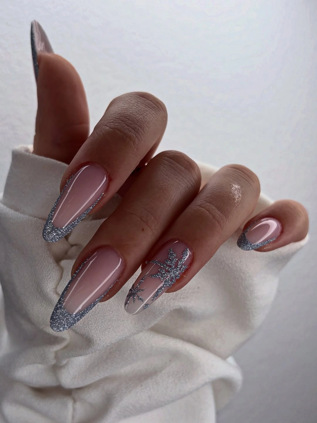 Long pointed pink nails with silver glitter borders and ribbon decoration