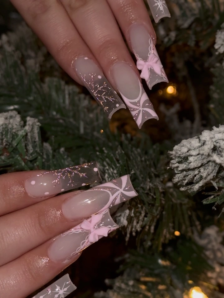 Long translucent square nails with pink ribbon bows and gold flecks