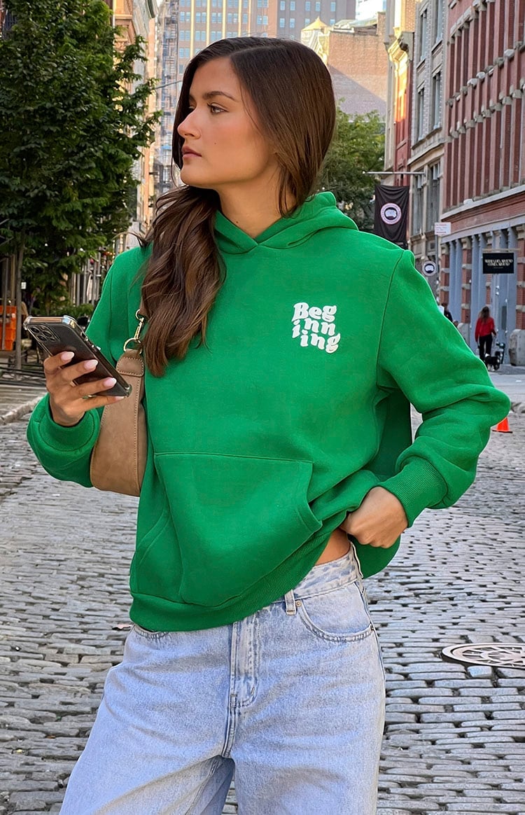 Green Graphic Hoodie with Denim Jeans and Shoulder Bag — Hoodie Outfits Women