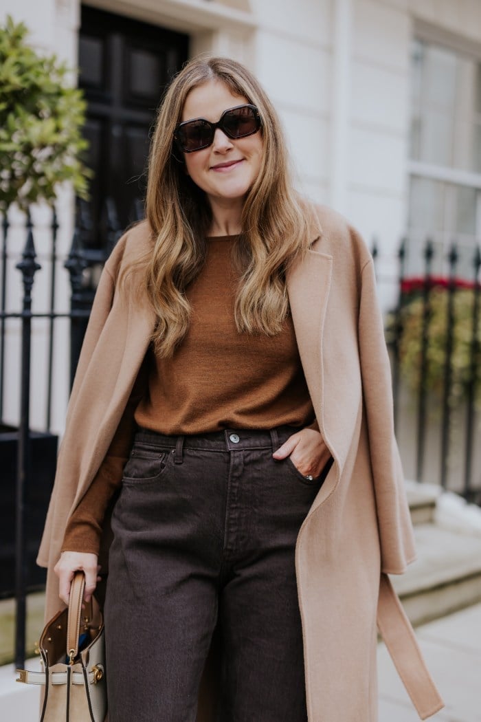 Camel Coat Draped Over Brown Sweater — London Outfits