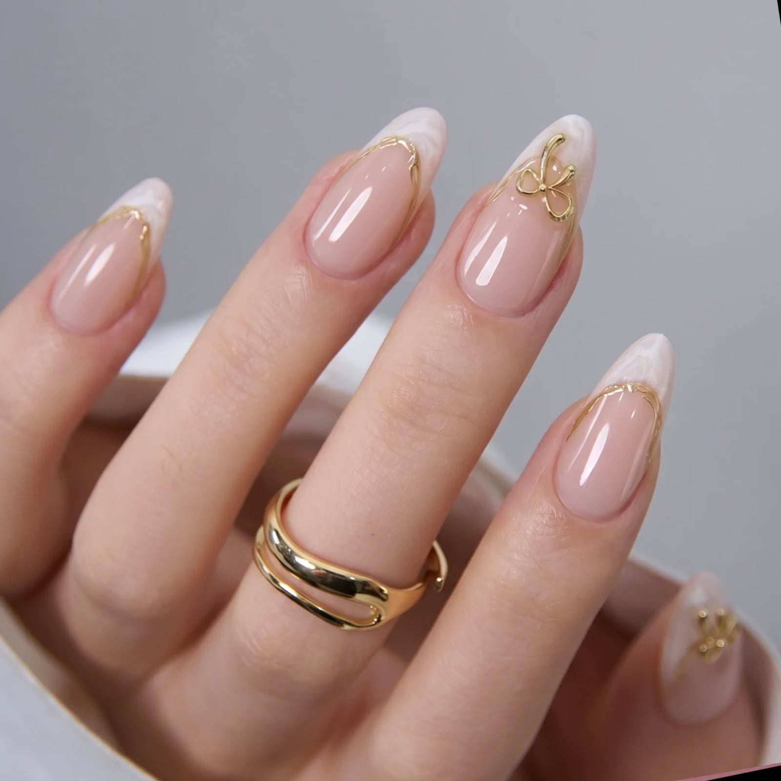 Nude Marble French With Gold Bow — Medium Almond Nails
