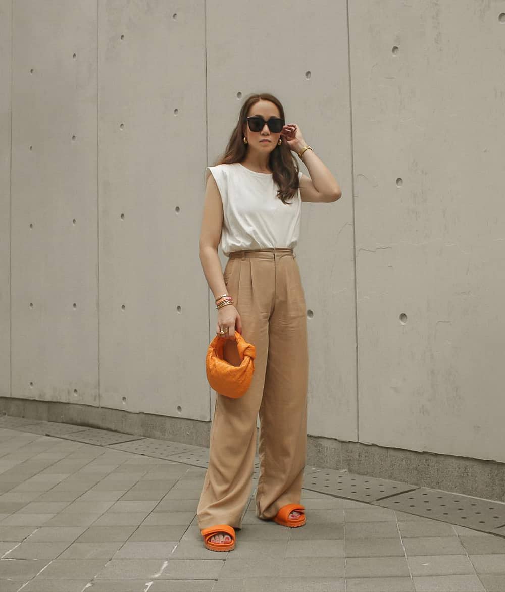 Beige wide-leg trousers with a white top and orange accessories — Simple Beige Pants Outfits