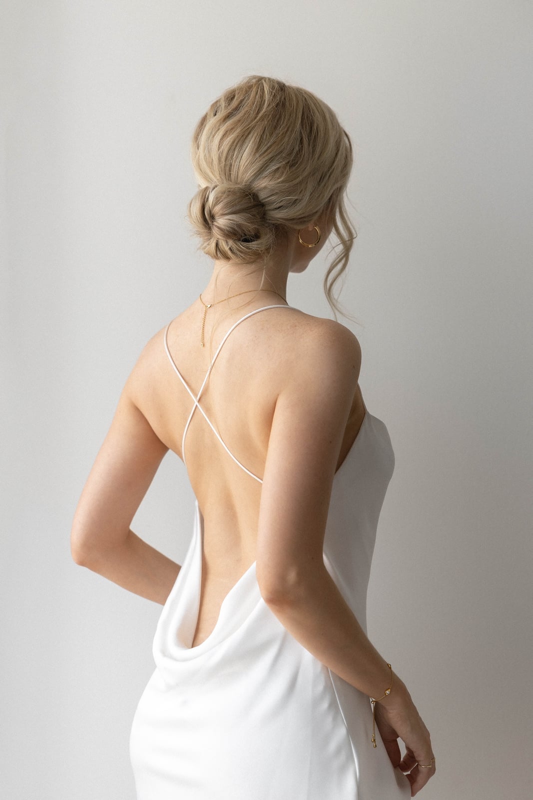 Blonde Wavy Low Bun With Loose Tendrils — Simple Low Bun Wedding Hair