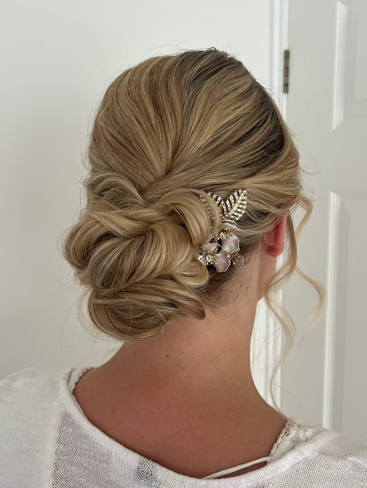 Blonde Twisted Low Bun With Floral Accessory — Simple Low Bun Wedding Hair