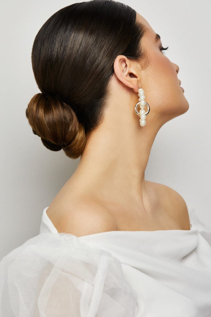 Dark Brown Sleek Low Bun Side View — Simple Low Bun Wedding Hair