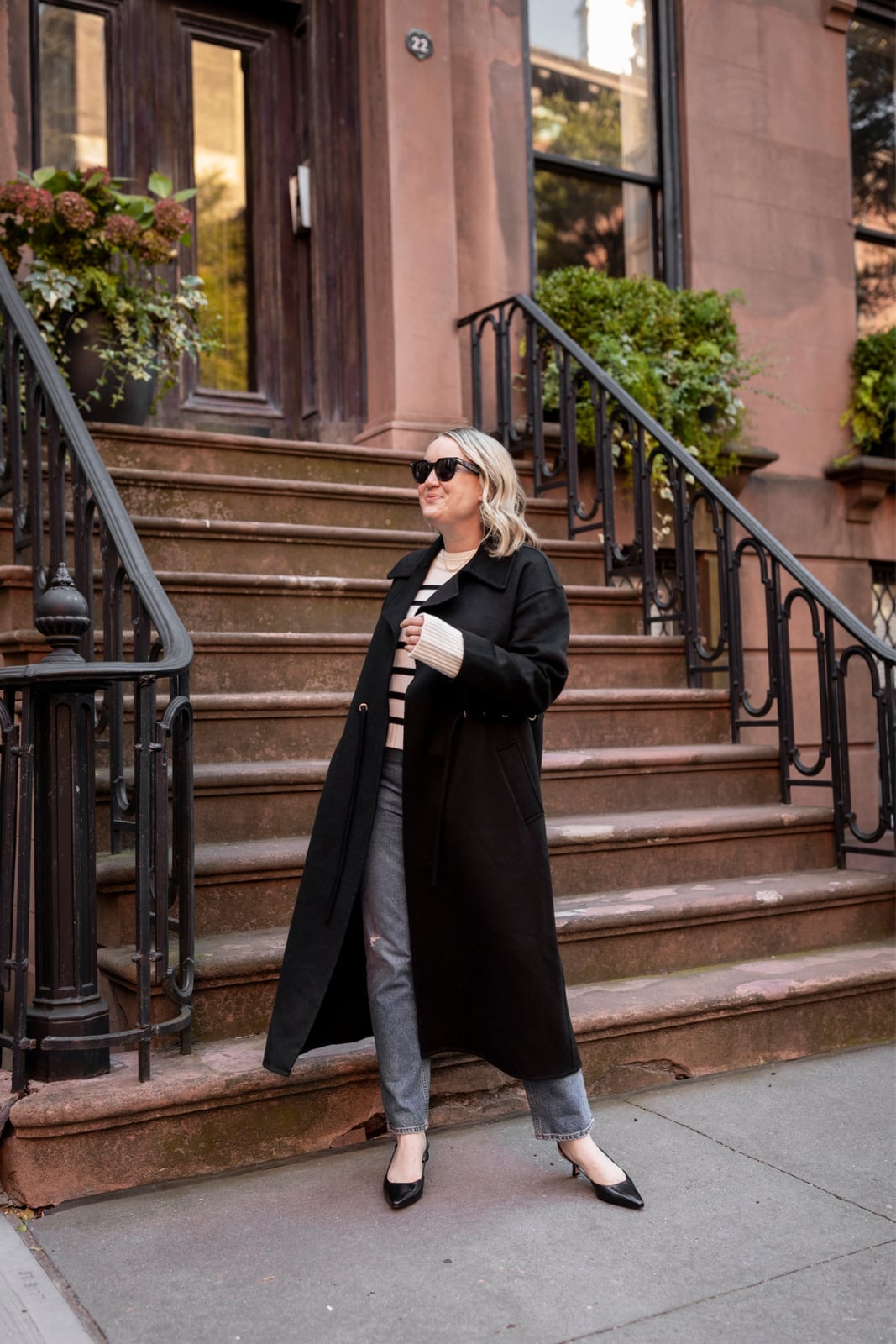 Long Black Coat Over Striped Sweater and Gray Jeans Long Black Coat Over Striped Sweater and Gray Jeans — Simple Work Party Outfits