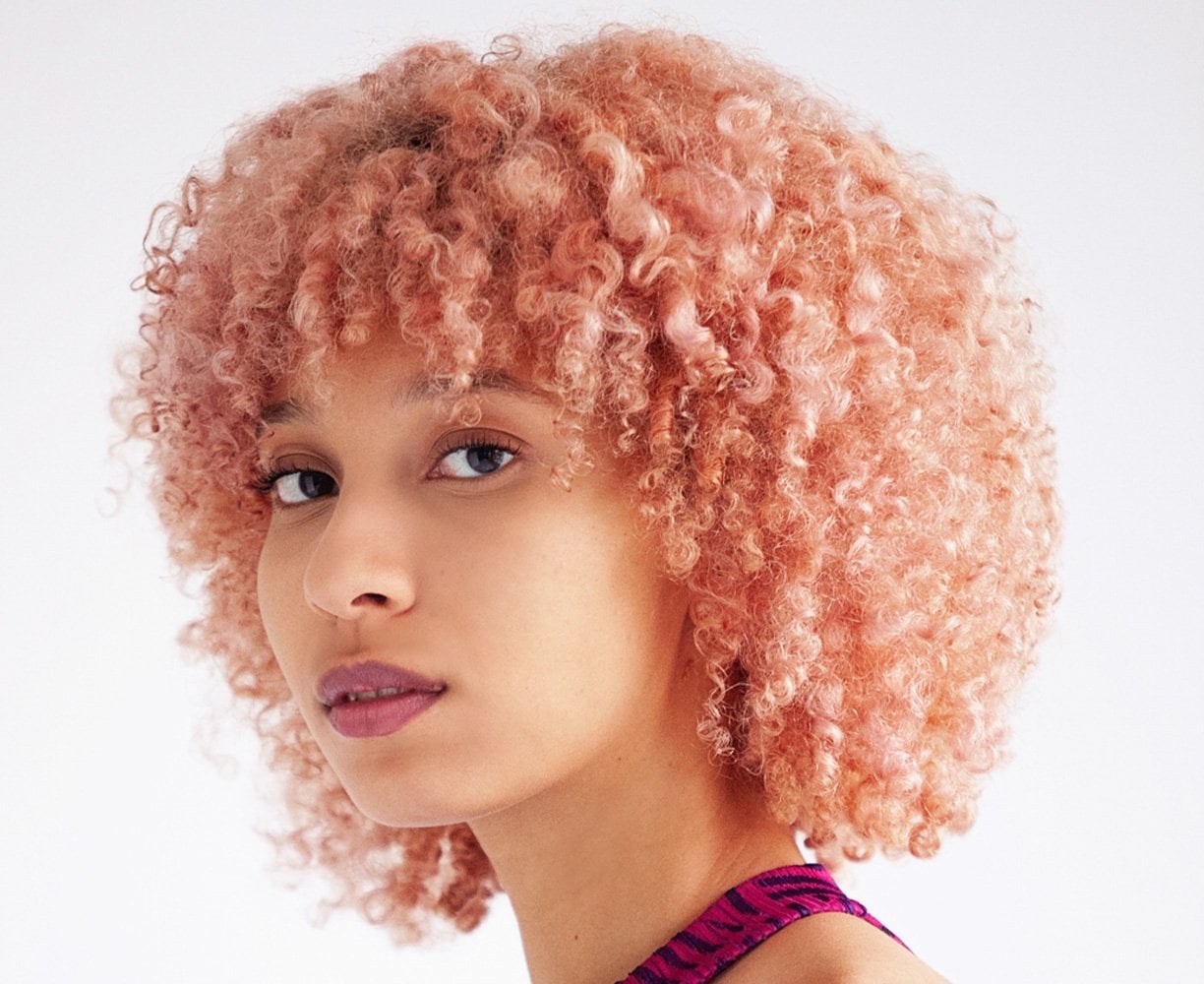 Ear Length Bob In Vibrant Coral Pink — Trendy Curly Hair Color