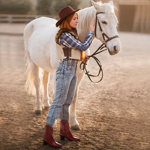 Red Cowboy Boots With Denim Jeans And Vest — Trendy Red Boots Outfit